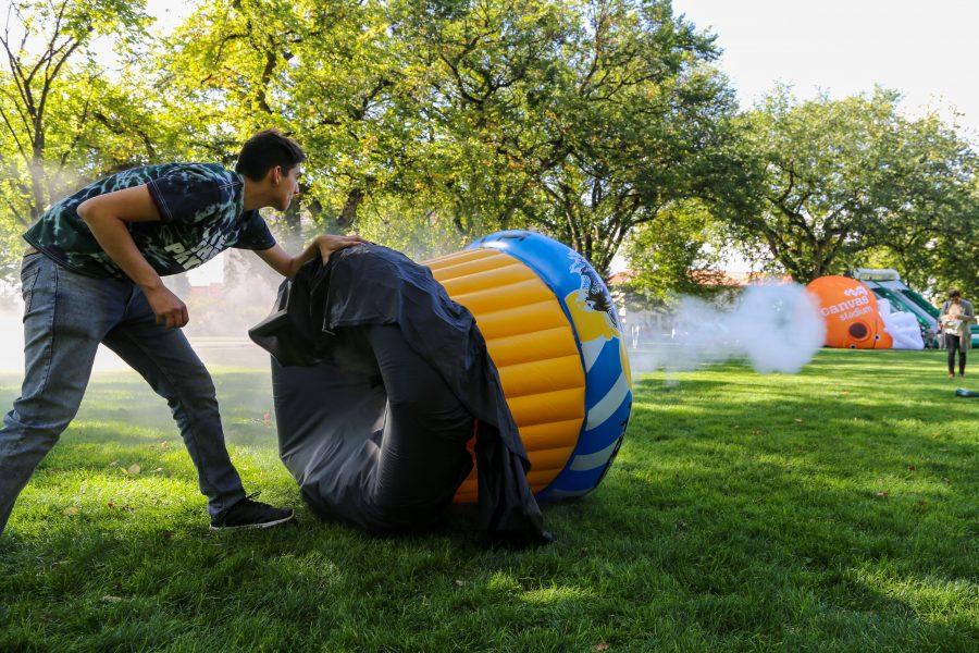 Senior Zoology student and Little Shop of Physics volunteer Andres Trelles uses a handmade fogging machine to create smoke rings on the oval during homecoming weekend Friday, Oct. 4th. (Brooke Buchan | Collegian) 