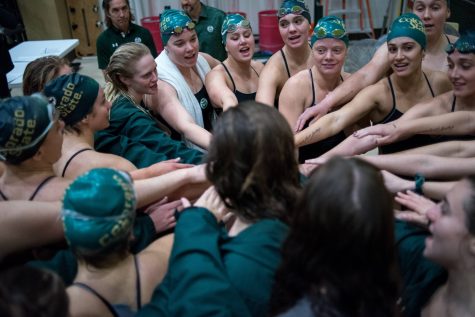 The Colorado State University Swim and Diving team cheer and congratulate the University of Kansas Jayhawks at the end of the day's competitions.