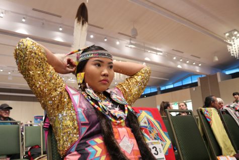 Heaven Old Coyote puts a beaded feather piece in their hair at the Native American Cultural Centers 37th Annual Pow Wow, hosted by the American Indian Science and Engineering Society, in the Lory Student Center