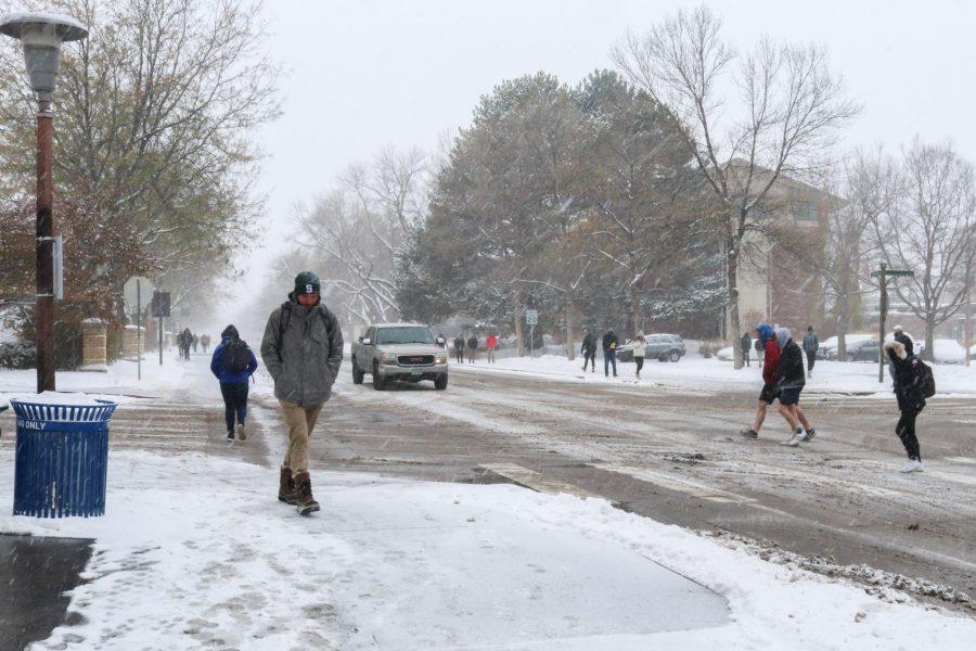 Colorado State University students walking through the snow at the intersection of Meridian Avenue and West Plum Street on campus, Oct. 29. (Anna von Pechmann | The Collegian)  
