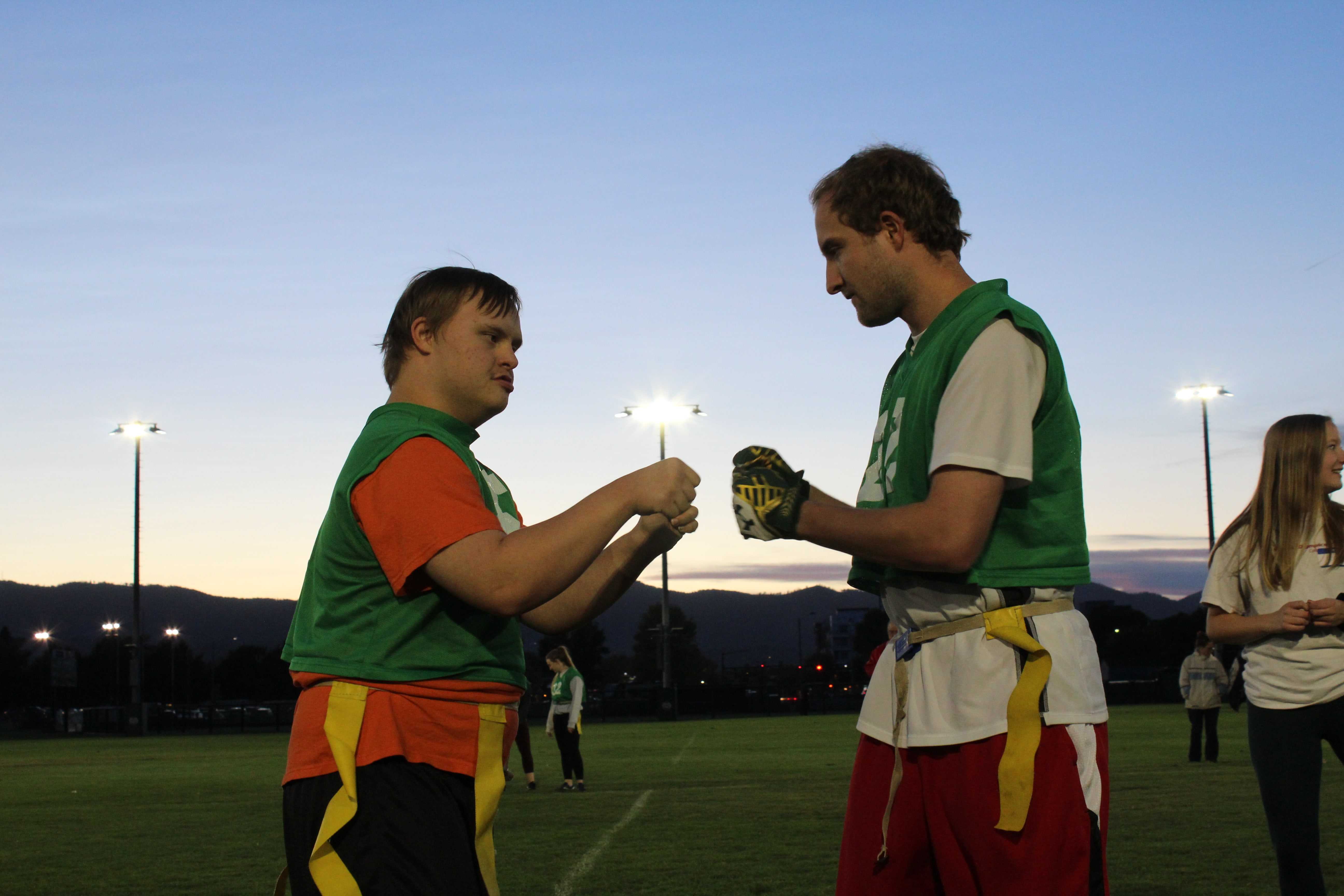 special olympics player fist bumps volunteer