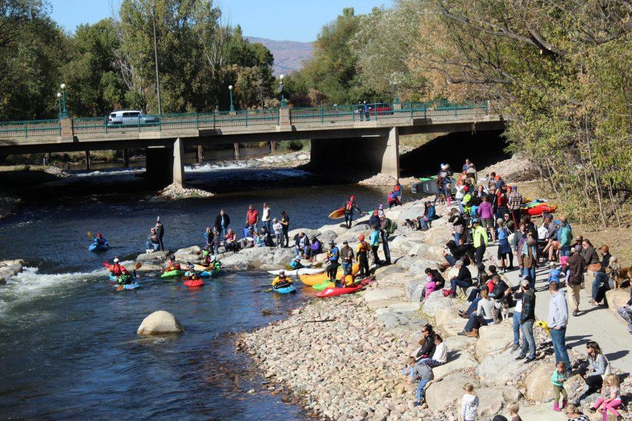 Fort Collins community members kayak and sit on the shore of the Poudre River during the grand opening of the Poudre River Whitewater Park off of N College and Vine Dr. Oct. 12. (Alyssa Uhl | The Collegian) 