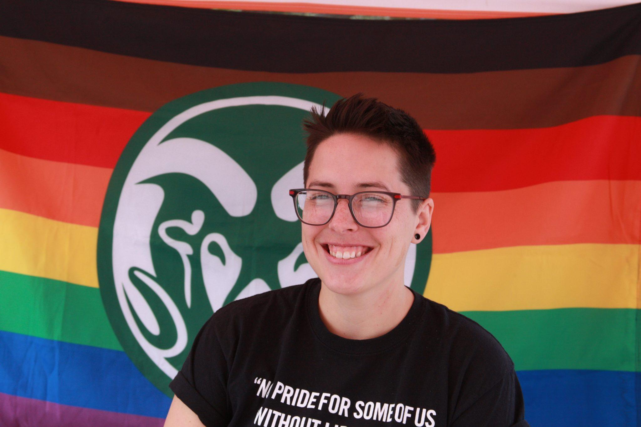 a person in front of a pride flag