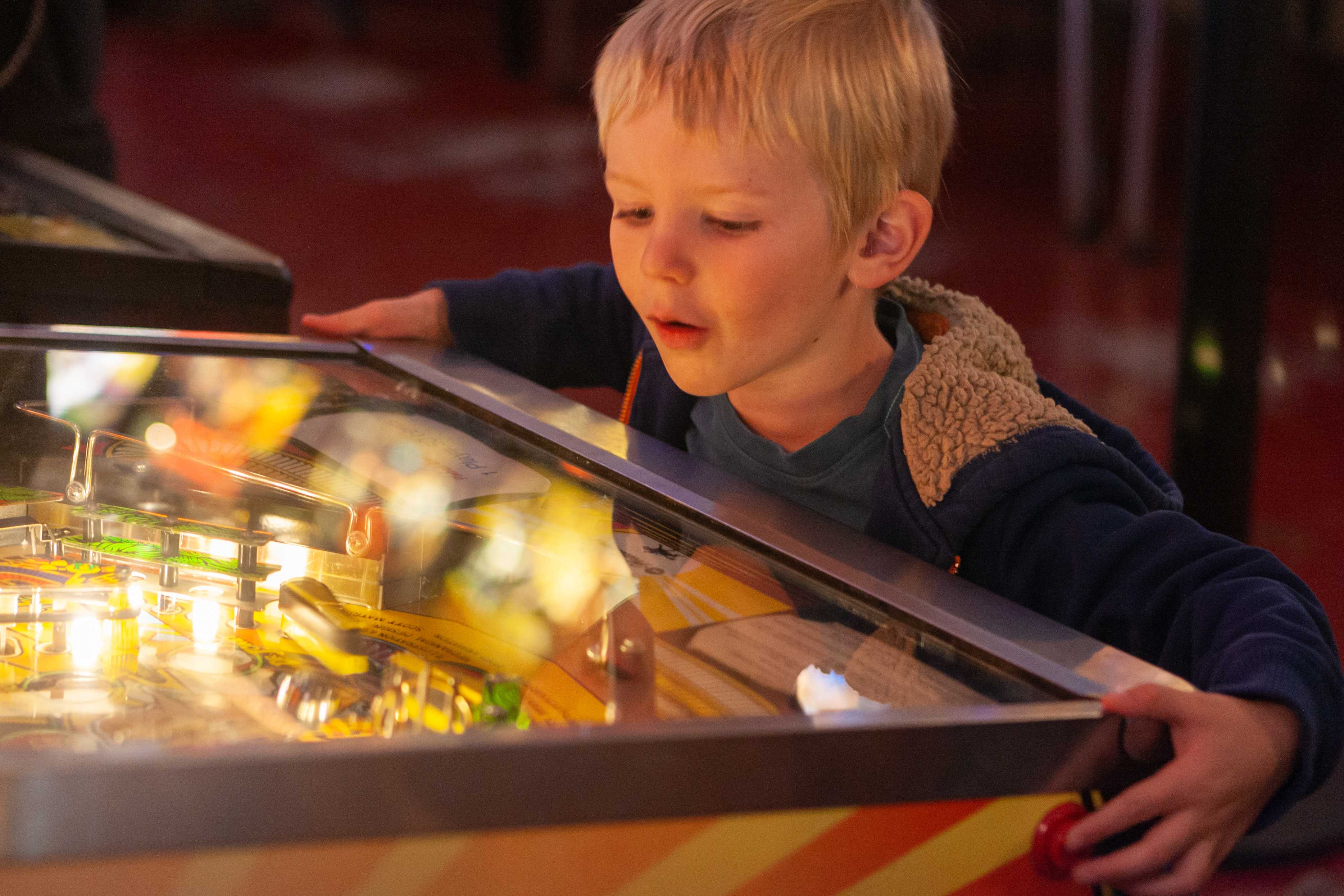 Boy plays arcade game