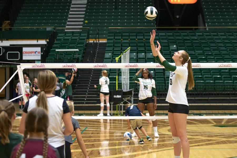 Kirstie Hillyer sets the ball to a child as they practice spiking the ball, during a Ram Volleyball Clinic on Oct.26 at Moby Arena. (Devin Cornelius | Collegian)