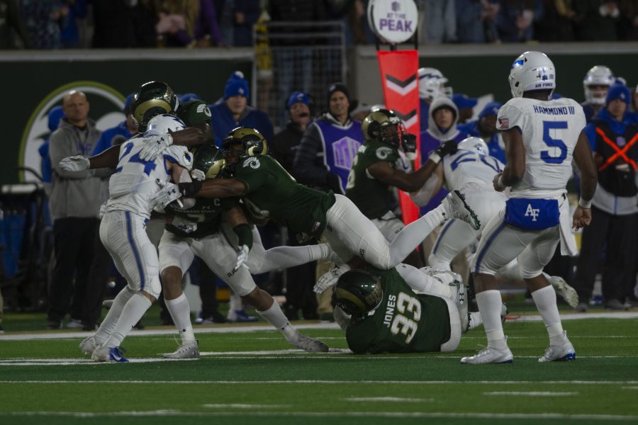 Colorado State defenders tackle Air Force running back Kadin Remsberg (24) in the Rams 38-13 loss to Air Force on Nov. 16 at Canvas Stadium. (Gregory James | The Collegian)