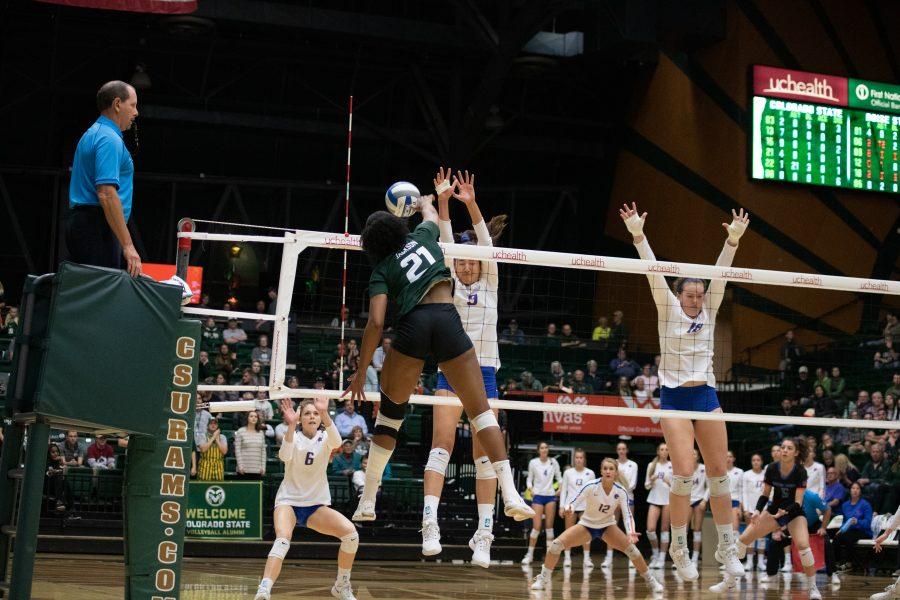 Outside hitter Jessica Jackson (21) spikes the ball past the defenders during the University's game against Boise State at Moby Arena on Nov. 16, 2019. CSU won three sets to zero. (Devin Cornelius | The Collegian)
