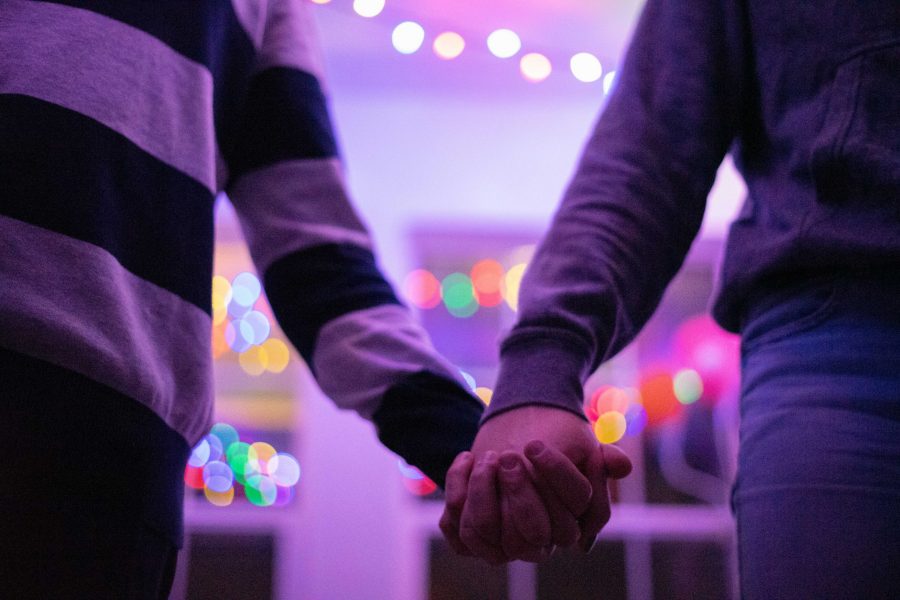 A couple holds hands. (Photo illustration by Skyler Pradhan | The Collegian) 