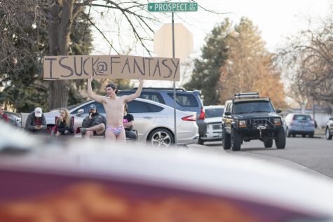Senior Marketing major Devon Heywood stands on the corner of Prospect Rd. on the afternoon of Jan. 25 in a speedo holding a sign which reads “I suck @ fantasy”. Heywood stood with the sign for an hour as punishment for falling in last place of his Fantasy Football league. At the beginning of the season Heywood “did not think this was a possibility” for him, but in the last week of the season his teams began performing poorly, consequently moving him to last place. “I had the choice between a spray tan, shaving my eyebrows or doing this,” said Heywood. “So I picked this.” (Lucy Morantz | The Collegian)