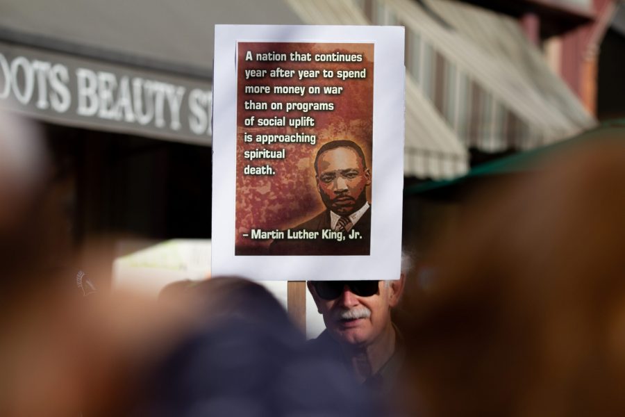 Attendees of the Dr. Martin Luther King Jr. Day march hold signs before walking from the Old Town Square to the Lory Student Center. (Matt Tackett | The Collegian)