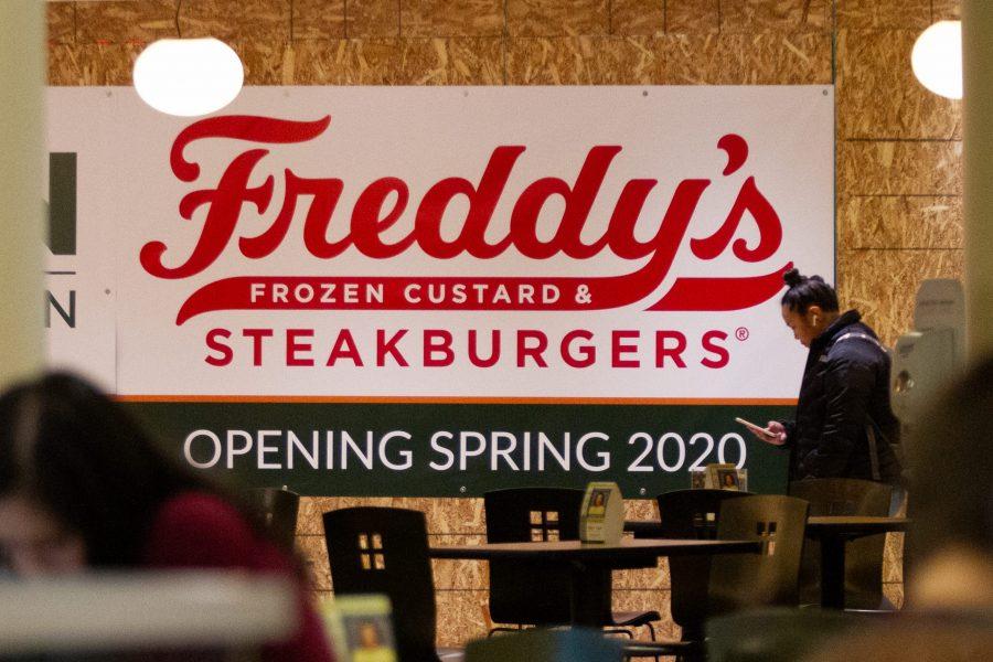 A sign reading Freddys Frozen Custard & Steakburgers hung on the plywood covering the space in the Lory Student Center where the restaurant will be. (Matt Tackett | The Collegian)