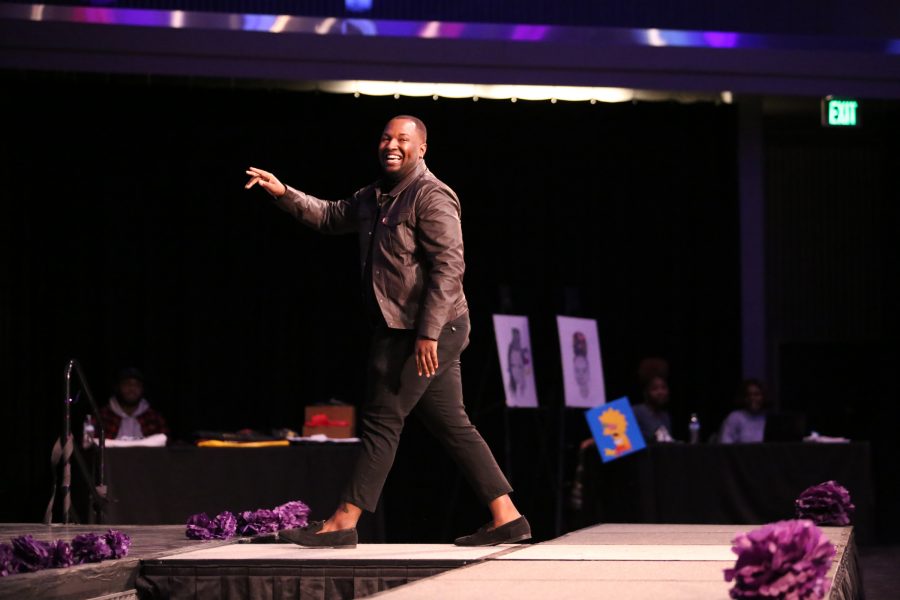 DeAndre Smith gives a smile and wave as he leaves the runway during the United Women of Color Hair Show Feb. 9 in the Lory Student Center Theater. (Forrest Czarnecki | The Collegian)