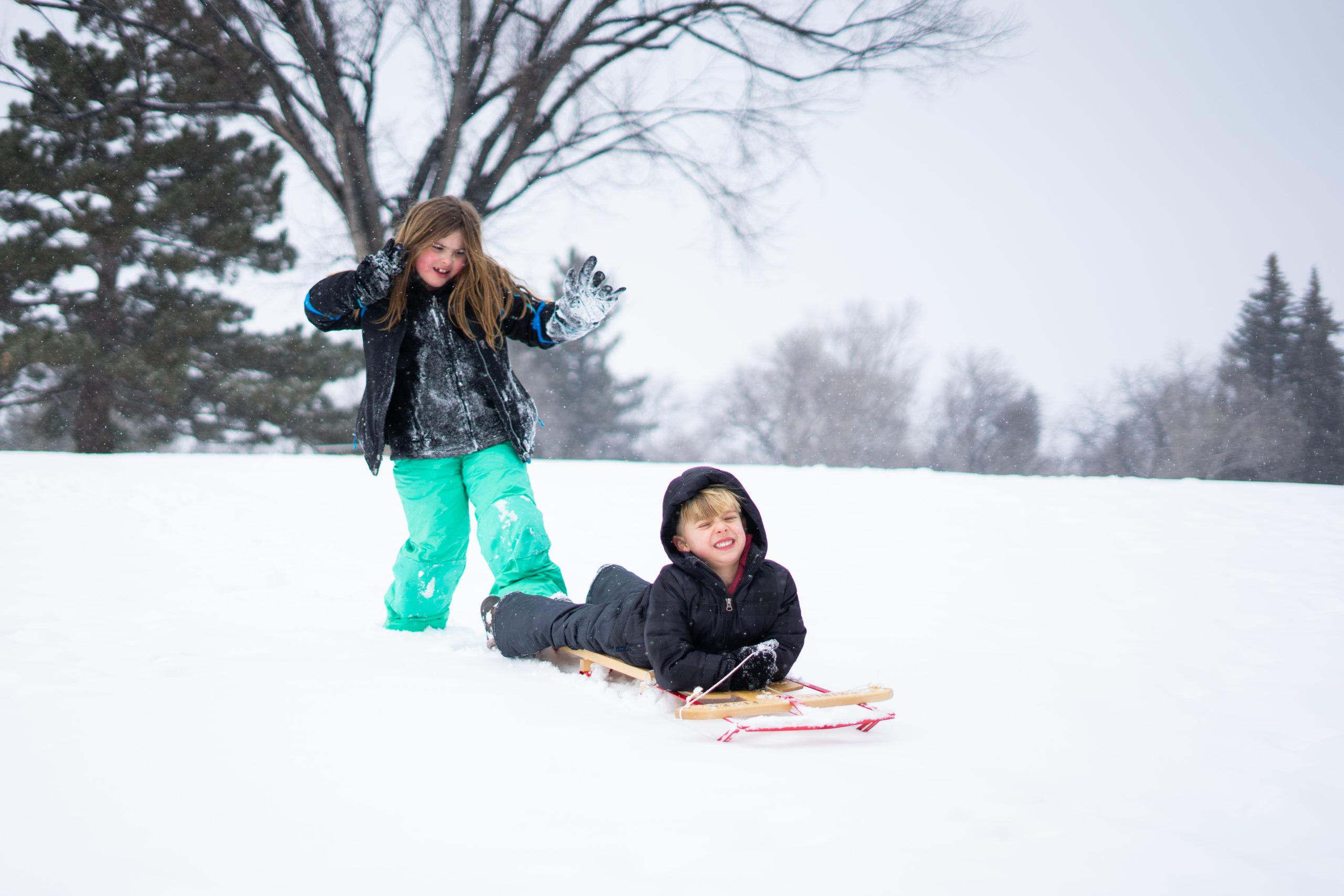 Girl and boy sledding