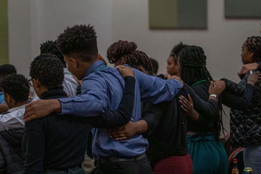 Students at the Black Student Activist Conference stand together with arms around each other while keynote speaker Patrice Palmer reminds students the importance of loving each other and holding the line in times when being an activist gets hard, Feb. 1. (Addie Kuettner | The Collegian)