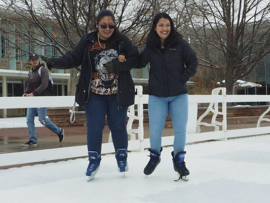 Bridget Reyna and Andrea Henriguez lock arms as they skate outside the Lory Student Center on Feb. 13. The Ice Skating rink was set up by the Black/African American Cultural Center in celebration of Black History month as a fun event for the community. (Gregory James | The Collegian)