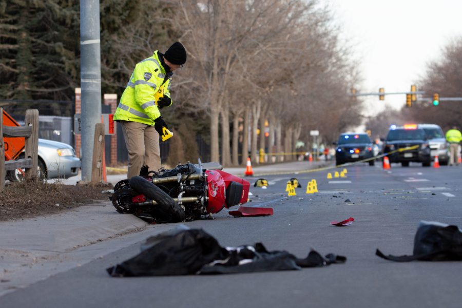 A Fort Collins Police Services investigator places markers on the scene of a car and motorcycle collision at the intersection of Prospect Road and Whitcomb Street Feb. 18. (Matt Tackett | The Collegian)