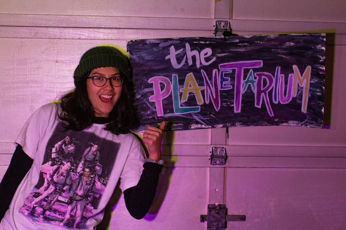 The Laundry Room venue in dark pink lighting with a guitar and drum set with a washer and dryer in the background