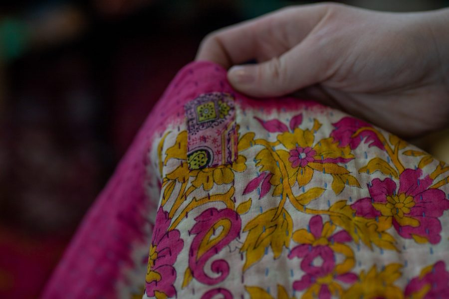 College of Health and Human Sciences student and human trafficking prevention organization volunteer, Megan Gillham, holds up a colorful sari made and sold by a woman who was a victim of human trafficking in India. U Count hosts a marketplace of handmade products from women in countries like India and Spain to make a profit and support themselves after escaping human trafficking. (Brooke Buchan | The Collegian) 