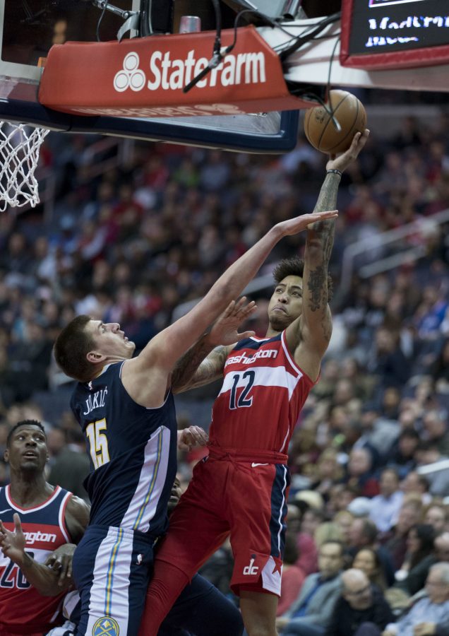 Nikola Jokic attempts to block a shot by Kelly Oubre Jr. as the Denver Nuggets played at Washington Wizards Mar. 23, 2018. (Photo via Keith Allison, Flickr)