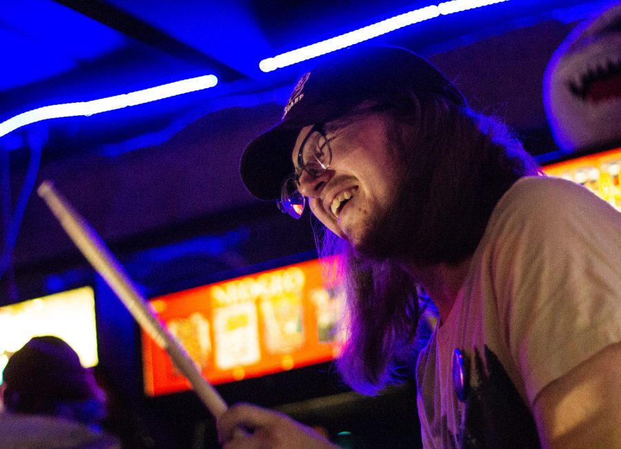 Nick Visocky of local band Yail smiles while drumming at their first show at Pinball Jones Campus West, ending their hiatus, Jan. 23 2020. (Monty Daniel | The Collegian)