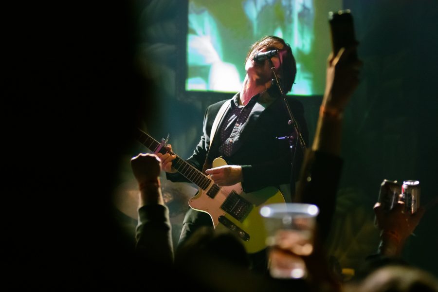 Fans sing and raise their drinks as Adam Turla, frontman of band Murder by Death, plays a concert at Washingtons, March 5. (Megan McGregor | The Collegian)