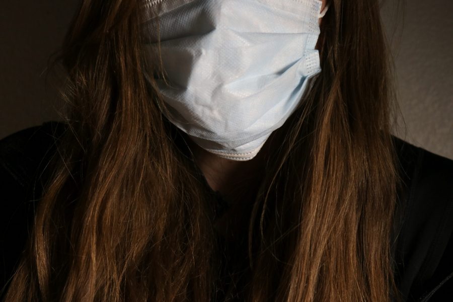 Woman wears a face mask to prevent the spread of disease. (Photo Illustration by Anna von Pechmann | The Collegian) 