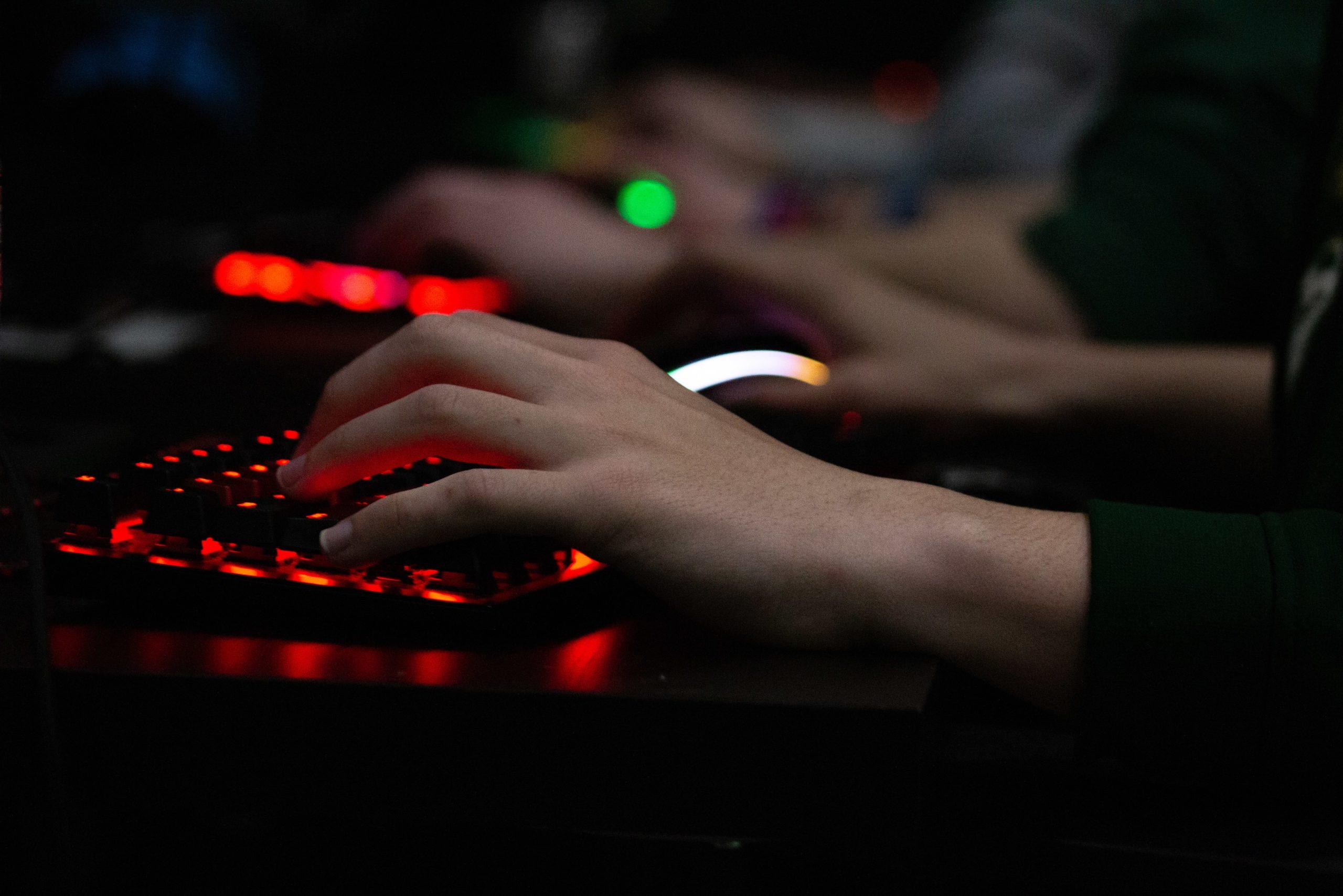 hands on a keyboard backlit with red light