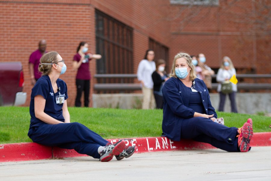 Two nurses sit outside Poudre Valley Hospital waiting for the Colorado Air National Guard 140th Wing F-16 flyover May 6. (Matt Tackett | The Collegian)