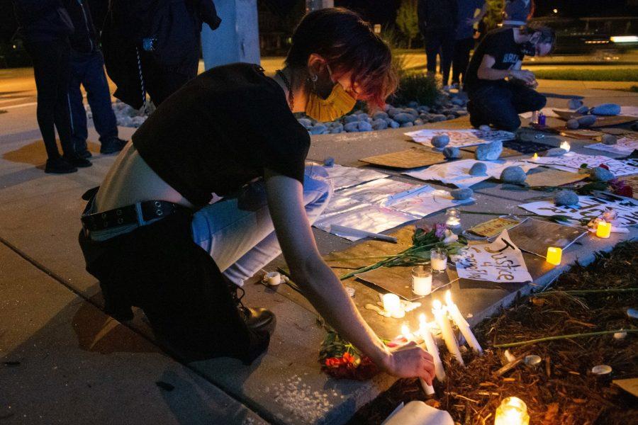 Emily Arnett lights a candle outside of the Fort Collins Police Services building on Timberline Road to protest police brutality in solidarity with the protesters in Minneapolis and around the country, May 29. (Matt Tackett | The Collegian)
