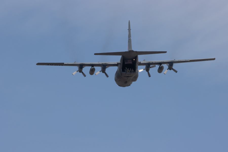 People wave from the back of a Lockheed C-130 Hercules as it flies over UCHealth Poudre Valley Hospital to show support for essential and health care workers on May 6, 2020. (Devin Cornelius | The Collegian)