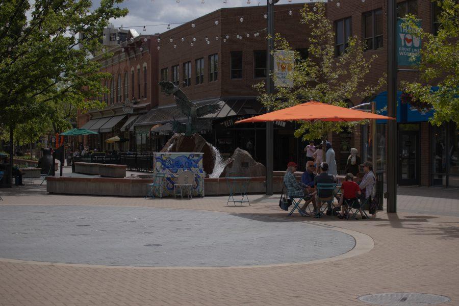 People relax in Old Town Square after a variance request was approved allowing restaurants in Larimer County are clear to re-open dine-in services at limited capacity. (Devin Cornelius | Collegian)