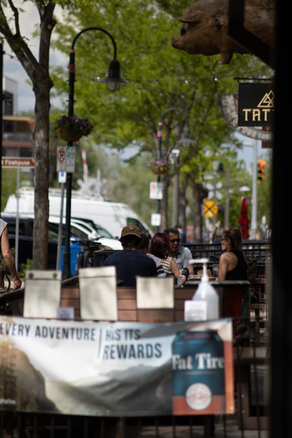 People sit at a restaurant in Old Town Fort Collins, after Larimer County got approval to re-open restaurants at limited capacity. (Devin Cornelius | Collegian)
