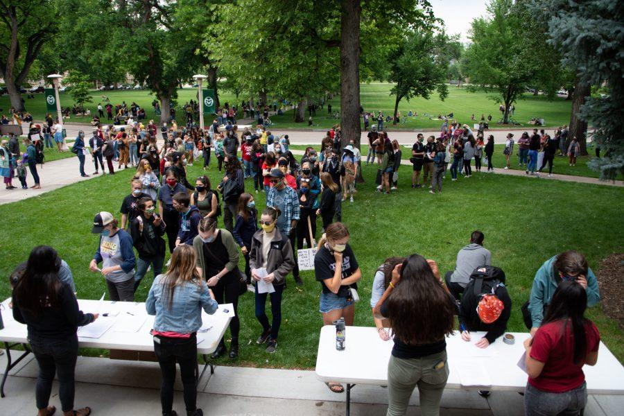 Fort Collins community members line up to sign petitions to remove school resource officers from Poudre School District at the Juneteenth rally in front of the Colorado State University Administration Building June 19. (Matt Tackett | The Collegian)