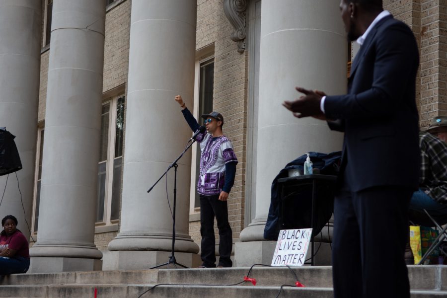 Christain Mills speaks with his fist in the air to a crowd gathered in front of the Colorado State University Administration Building for the Juneteenth rally June 19. (Matt Tackett | The Collegian)