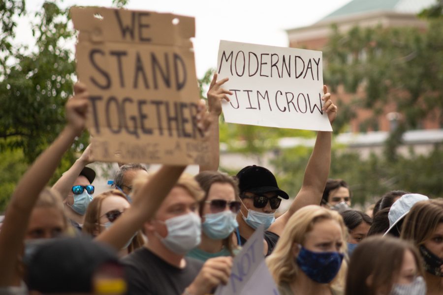 A protester holds up a sign that says “Modern Day Jim Crow” on it during a protest by City Hall on June 2. (Devin Cornelius | The Collegian)
