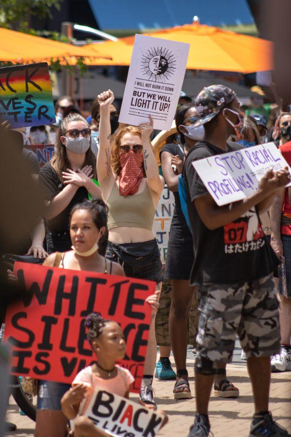 A protester holds up a sign and the Black Power Fist while protesting at the Old Town Square protest on June 5, 2020. (Devin Cornelius | Collegian)