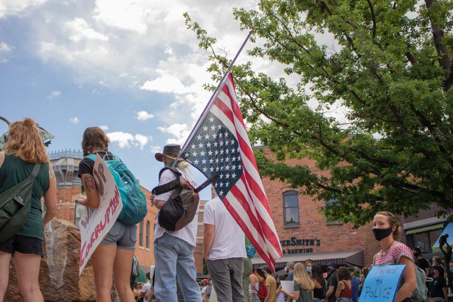 A protester holds an upside down flag during a protest in Old Town Square on June 5, 2020. (Devin Cornelius | Collegian)