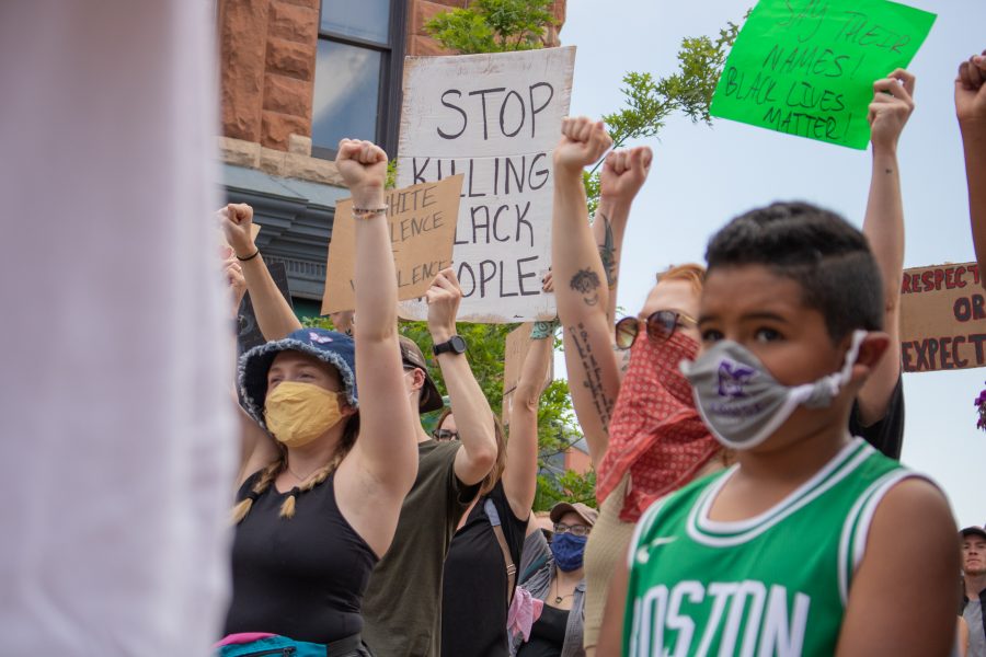 Protesters hold up their fists as hundreds gather in Old Town Square to protest police brutality against Black people, on June 5. (Devin Cornelius | The Collegian)