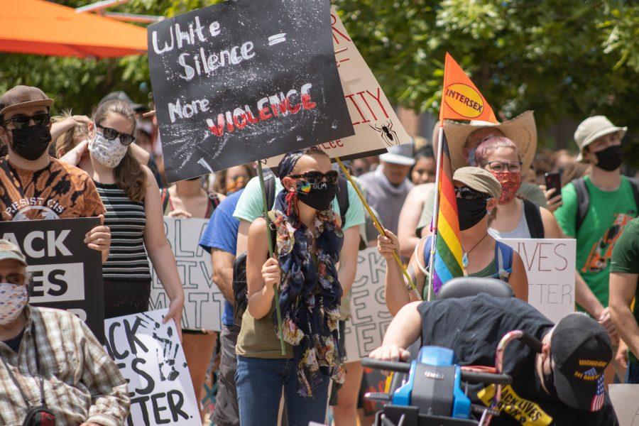 A woman holding a sign that says "White Silence = More Violence, while at the Old Town Square protest on June 5, 2020. (Devin Cornelius | Collegian)