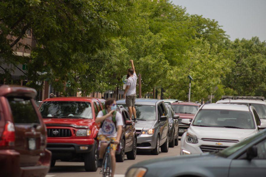 A man stands on his car while traffic is stopped due to protesters marching in Old Town, on June 5, 2020. (Devin Cornelius | Collegian)