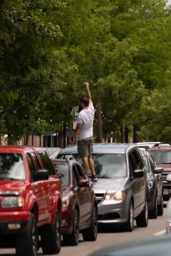 A man stands on his car while traffic is stopped due to protesters marching in Old Town, on June 5, 2020. (Devin Cornelius | Collegian)