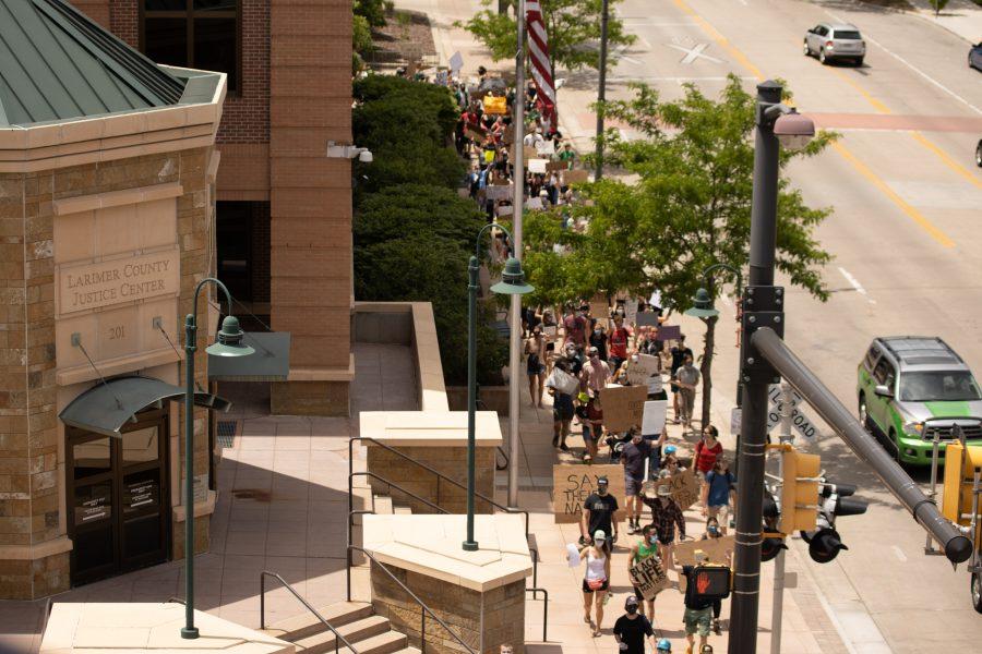 Protesters march past the Larimer County Justice Center during a protest against police brutality on June 5, 2020. (Devin Cornelius | Collegian)