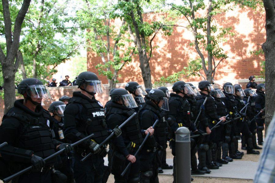 Police officers form a line in front of the Aurora Municipal Center on June 27. Later on the officers would walk in the line to push protestors out of the park. (Katrina Leibee | The Collegian)
