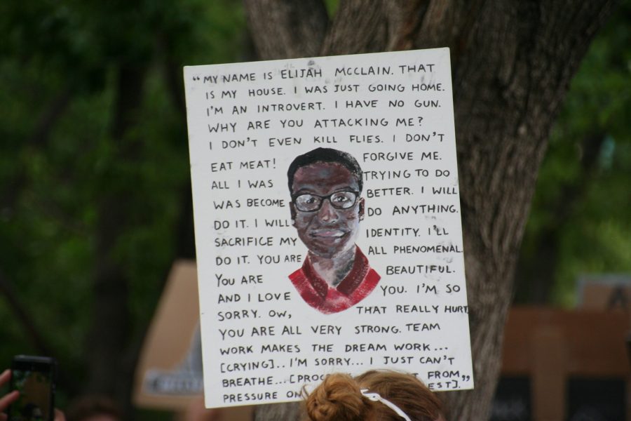 A protestor holds up a sign outside the Aurora Municipal Center on June 27. The sign reads the words of Elijah McClain, who was killed in August 2019. (Katrina Leibee | The Collegian)