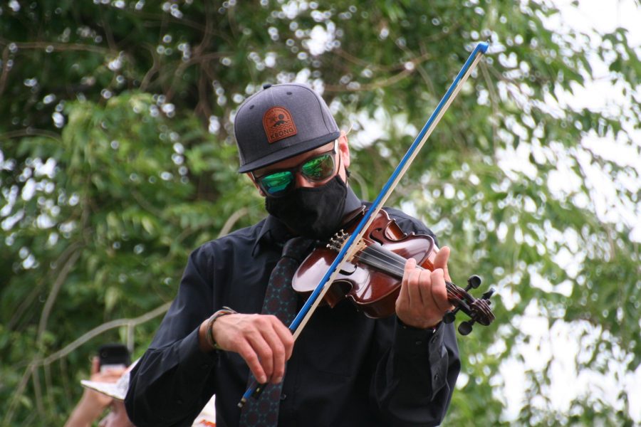 A protestor plays their violin while standing on a bench during the protest in Aurora on June 27. Many other protestors also brought their instruments out. (Katrina Leibee | The Collegian).