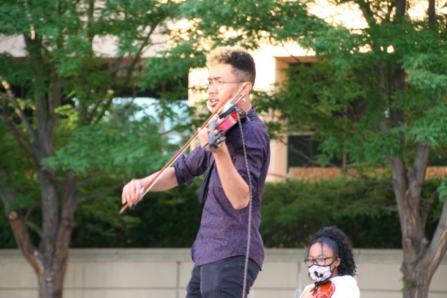 A violinist plays for protestors outside the Aurora Municipal Center on June 27. Protestors were asked to bring their string instruments in honor of Elijah McClain played violin (Katrina Leibee| The Collegian).