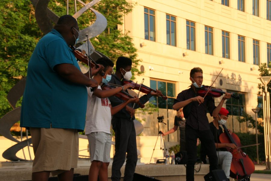 Violinists gather to play in honor of Elijah McClain. Protestors gathered around to listen to the music before being pushed out by police. (Katrina Leibee | The Collegian).