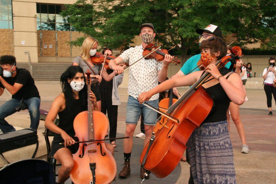 Violinists gather to play in honor of Elijah McClain. Protestors gathered around to listen to the music before being pushed out by police. (Katrina Leibee | The Collegian)