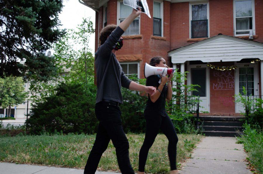 Roesler and Wilson  lead the march past a house with Black lives matter written on the brick. (Reed Slater | Collegian)