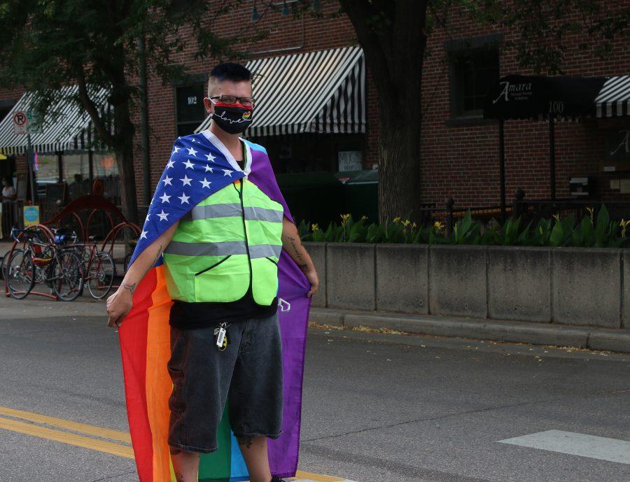 A volunteer at the Northern Colorado Pride March stands in the middle of the crosswalk at College Avenue and Olive Street to ensure marchers safely cross the road July 17, 2020. (Serena Bettis | The Collegian)